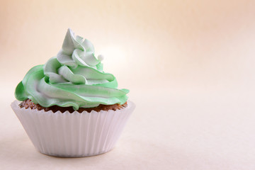 Delicious cupcake on beige background