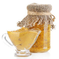 Assortment of mustard in glass jar and sauce-boat isolated