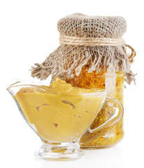 Assortment of mustard in glass jar and sauce-boat isolated