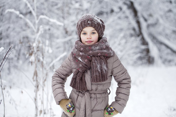 Happy little girl on the background of a winter park