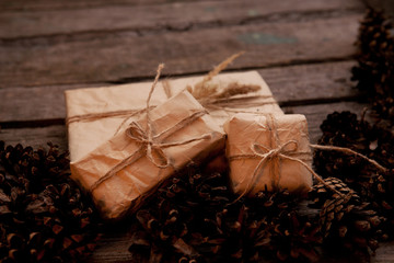 Vintage gift on wooden background with cones