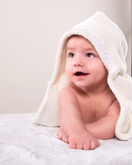 the infant lying on white towel