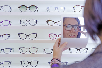 trying on glasses with a small mirror