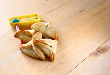 Hamantaschen cookies or hamans ears and noisemaker for Purim cel
