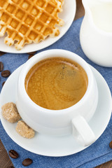 cup of coffee, waffles and a jug of milk, top view