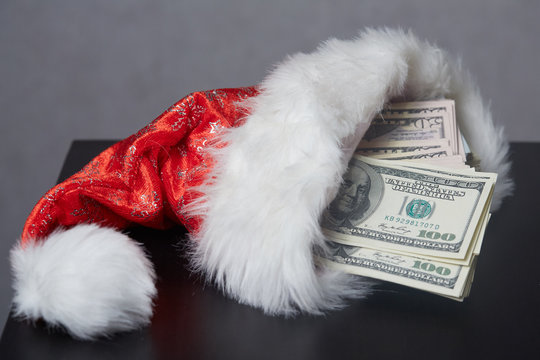 money in a Christmas cap Santaklaus