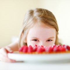 Adorable little girl and raspbrerry cake