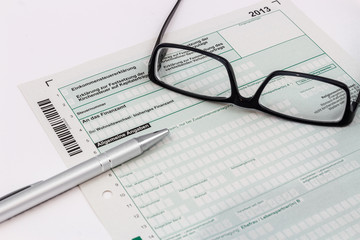 Formular Einkommensteuererklärung mit Kugelschreiber und Brille