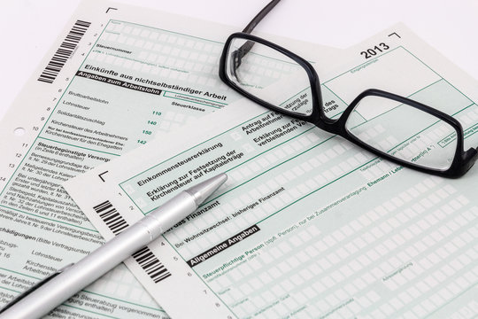 Formular Einkommensteuererklärung mit Kugelschreiber und Brille