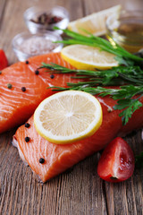 Fresh salmon with spices and lemon on wooden table