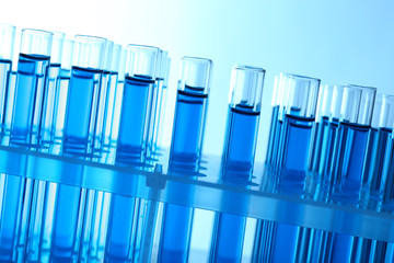 Blue water in a transparent test-tube on light background