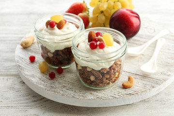 Healthy layered dessert with muesli and berries on table