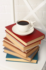 Pile of books with cup of hot drink