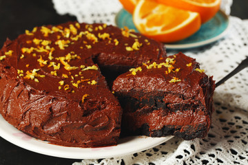 Chocolate cake with chocolate cream on wooden table close-up