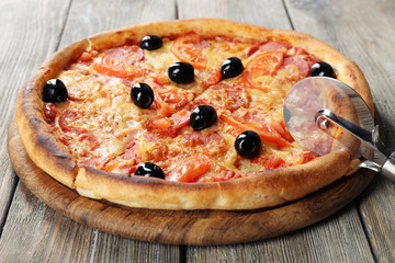 Tasty pizza with black olives and round knife