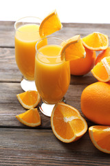 Fototapeta na wymiar Freshly squeezed orange juice on wooden table