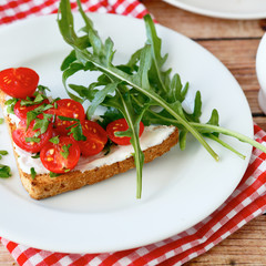 Delicious bruschetta with slices of tomatoes on a white plate