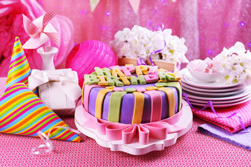 Delicious birthday cake on table on bright background