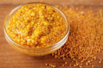 Mustard in bowl on wooden background