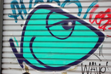 Graffiti eines Fisches auf den Lamellen eines Garagentors