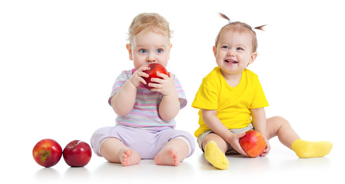 Baby boy and girl eating healthy food isolated