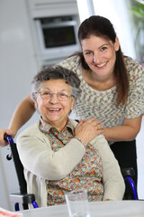 Portrait of elderly woman in wheelchair with homecarer