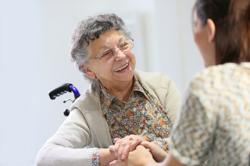 Elderly woman sharing good time with home carer - obrazy, fototapety, plakaty