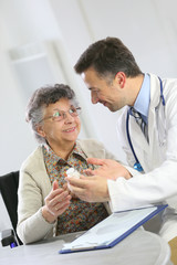 Doctor with elderly woman showing medical prescription