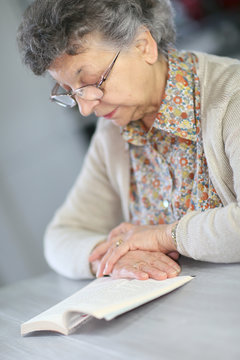 Portrait of elderly woman reading book