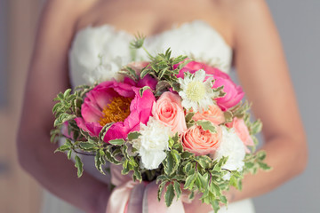 Obraz na płótnie Canvas Close-up of bride holding bouquet