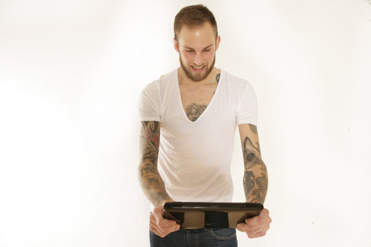 Junger Mann mit Tablet-PC besch&auml;ftigt