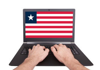 Hands working on laptop, Liberia
