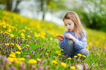 Naklejka na ściany i meble Adorable little girl in dandelion flowers
