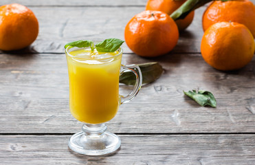 mandarin  juice with leaf mint and ice cube on wooden background