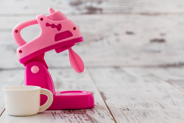Pink Plastic Toy Machines on White Wooden Background