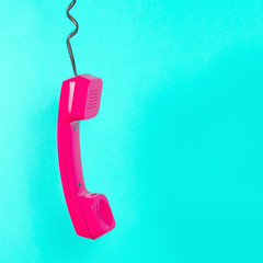 Telephone hanging on blue background, vintage style photo