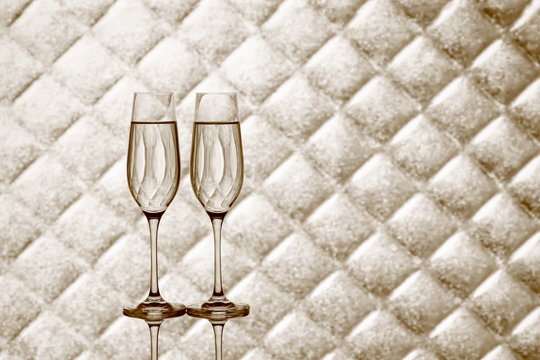 Two champagne glasses on blurred checkered background