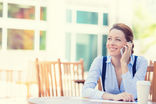 happy woman talking on mobile phone outside corporate office