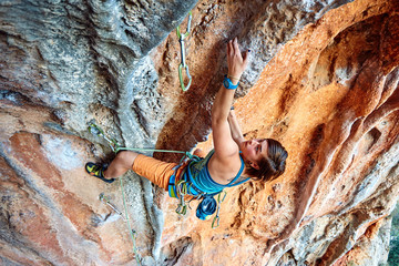 Rock climber climbing up a cliff