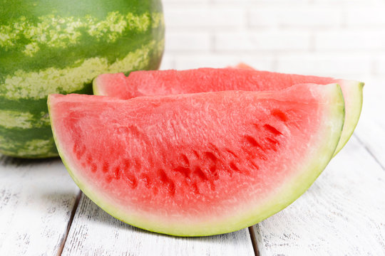 Juicy watermelon on table on brick wall background