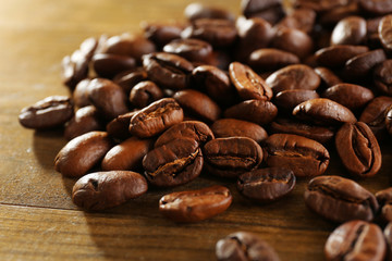 Coffee beans on wooden background, close-up