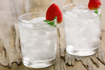 Glasses with ice cubes on wooden table