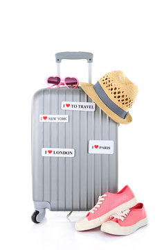 Travel suitcase, sunglasses, converse and hat isolated on white