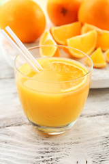 Glass of orange juice with straw and slices