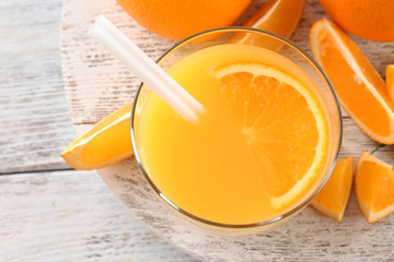 Glass of orange juice with straw and slices