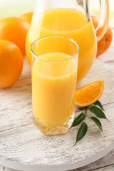 Glass of orange juice and oranges
