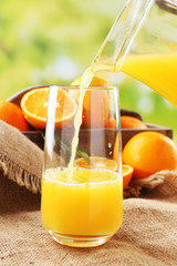 Pouring orange juice from glass carafe,