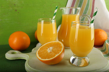 Glass of orange juice with slices and striped fabric