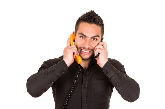 closeup shot of handsome man using corded telephone and cell