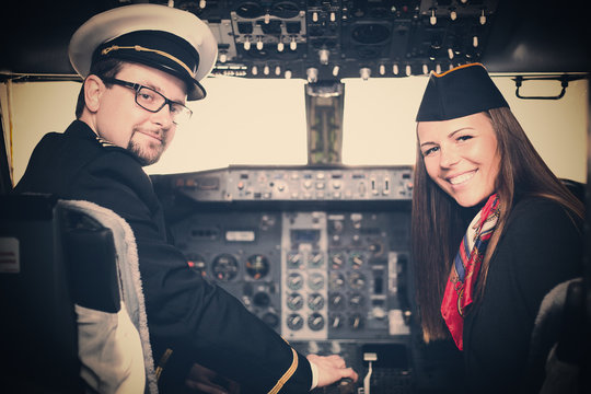 Pilot and stewardess sitting in an airplane cabin